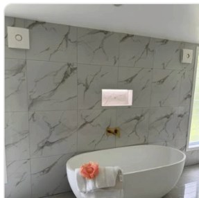 Marble-tiled bathroom with freestanding bath